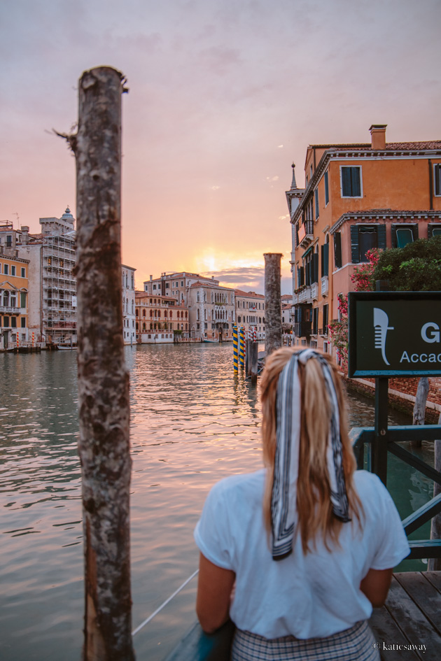 girl looking out over the grand canal of venice at sunset