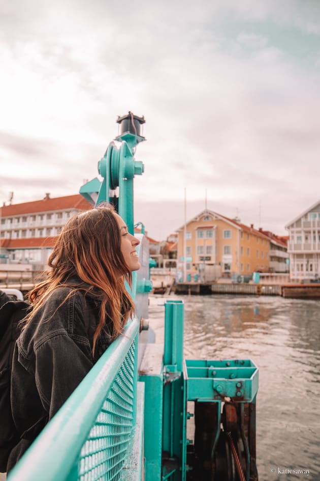 girl in a black jacket on the ferry with marstrand in the background