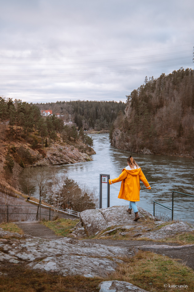girl walking over a cliff towards the trollhättan hydroplant