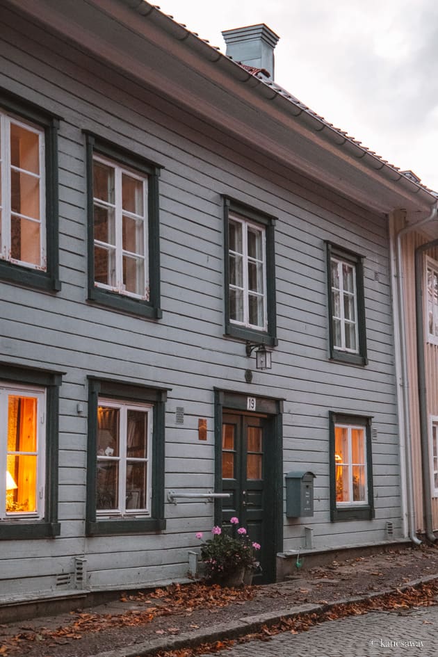 a green door with a christmas wreath on a blue wooden house in kungälv