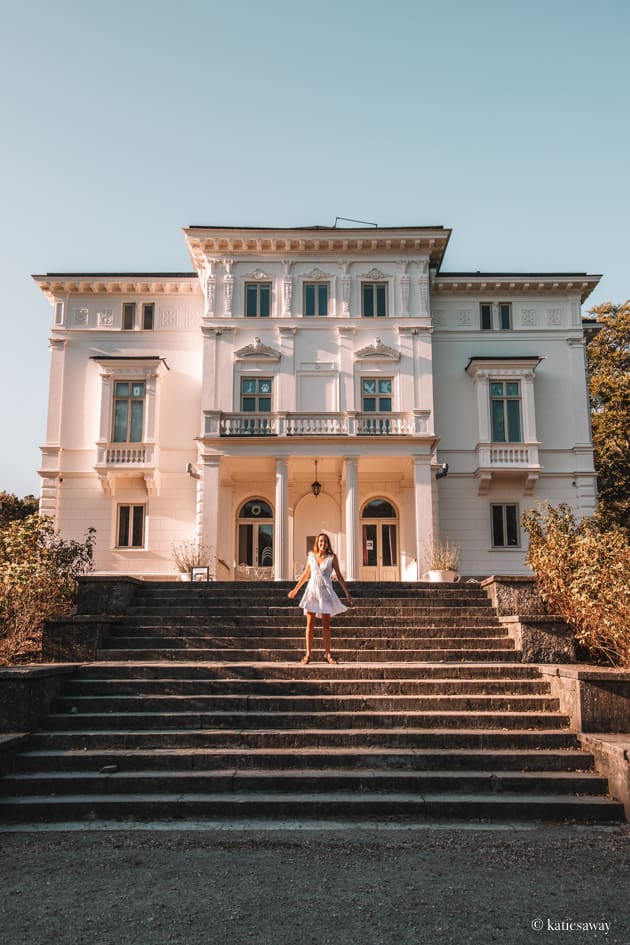 girl in a white dress walking down the steps infront of nolhaga slott in alingsas