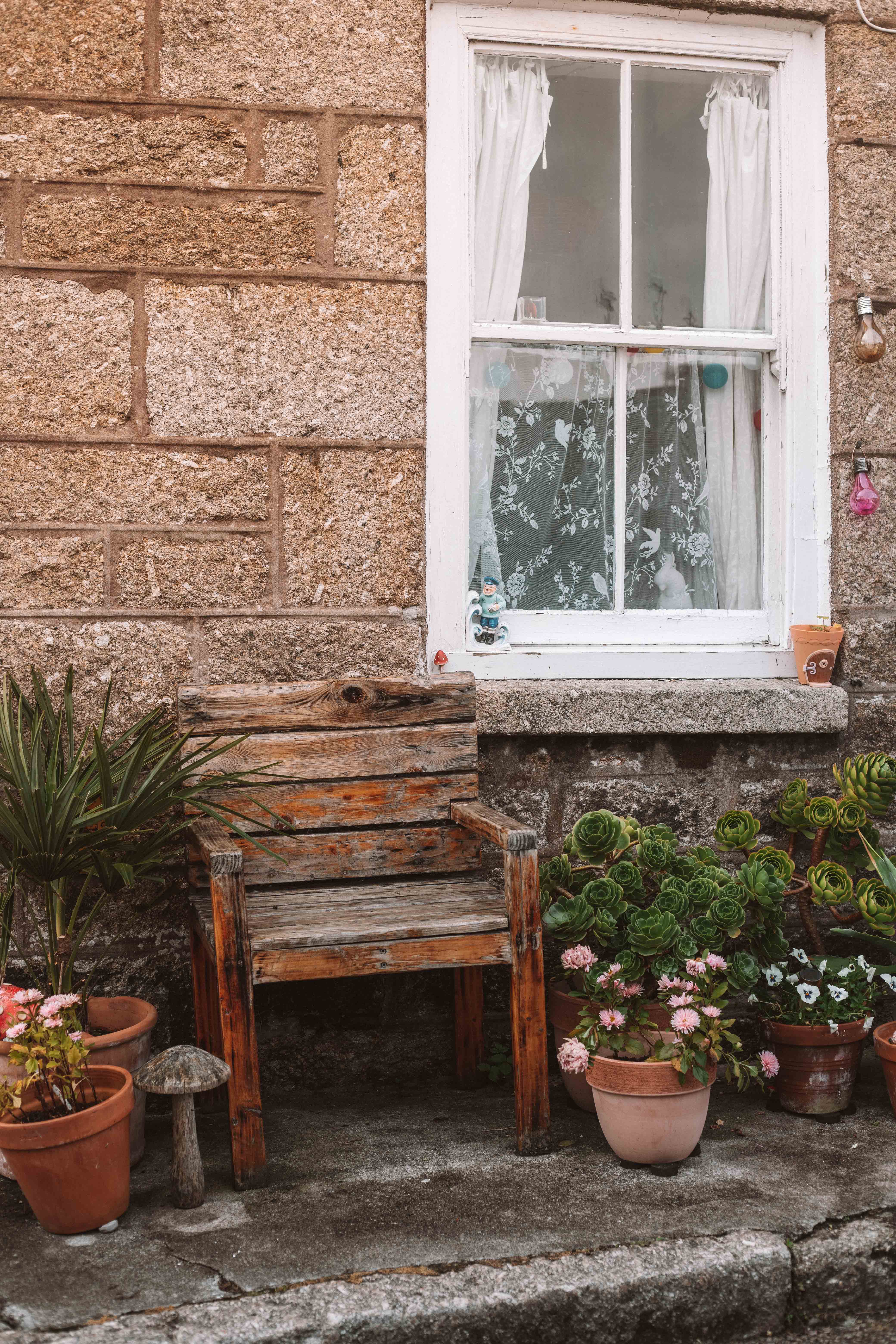 Little bench outside a sandstone cottage in Mousehole, Cornwall