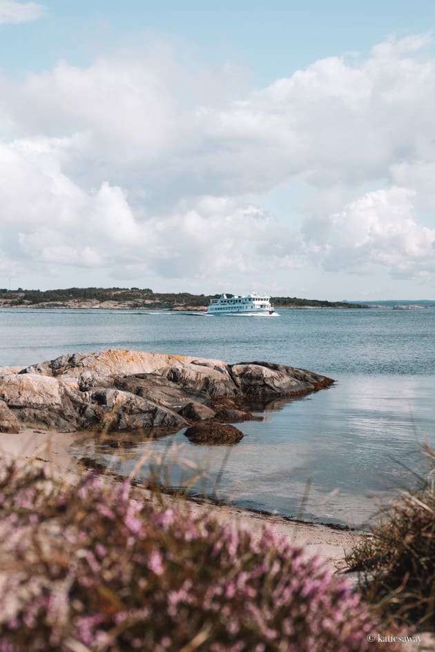 the sandy beach on vrångö island with a view of the gothenburg archipelago and a ferry behind.