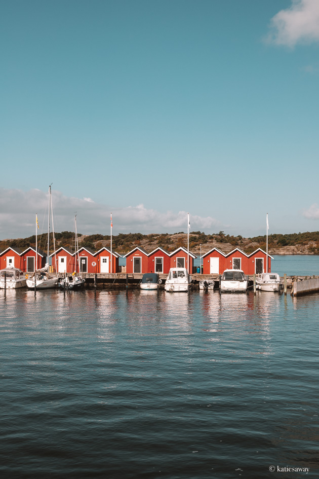 a row of red boat houses seen from the vrångö ferry
