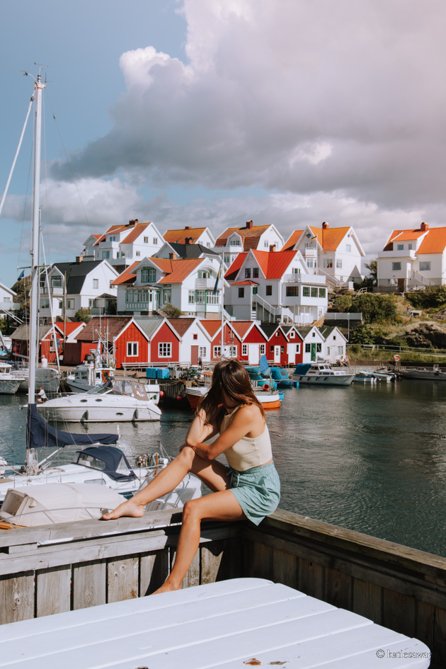 girl sitting by åstol island harbour west sweden