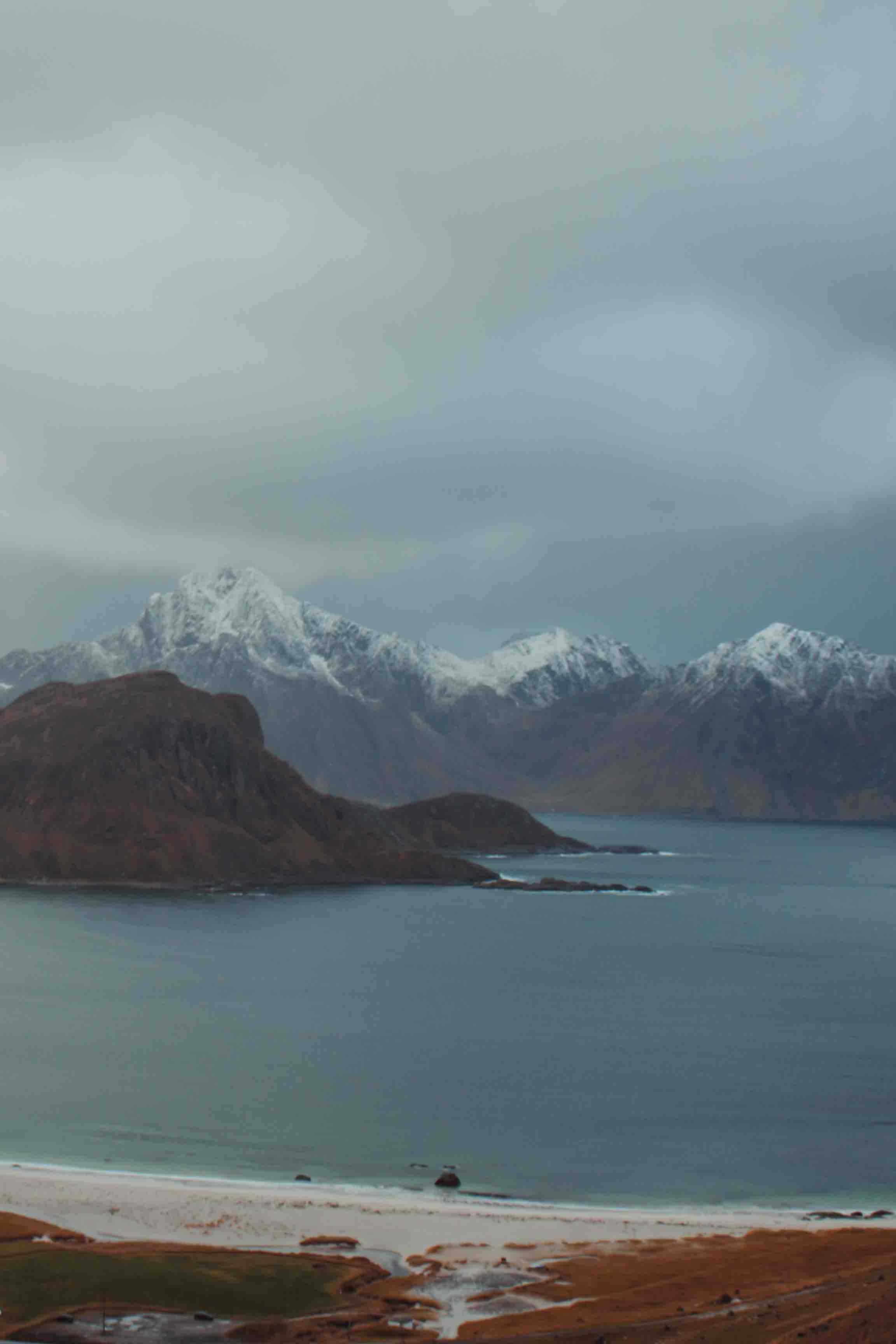 haukland beach with snow covered mountains lofoten islands