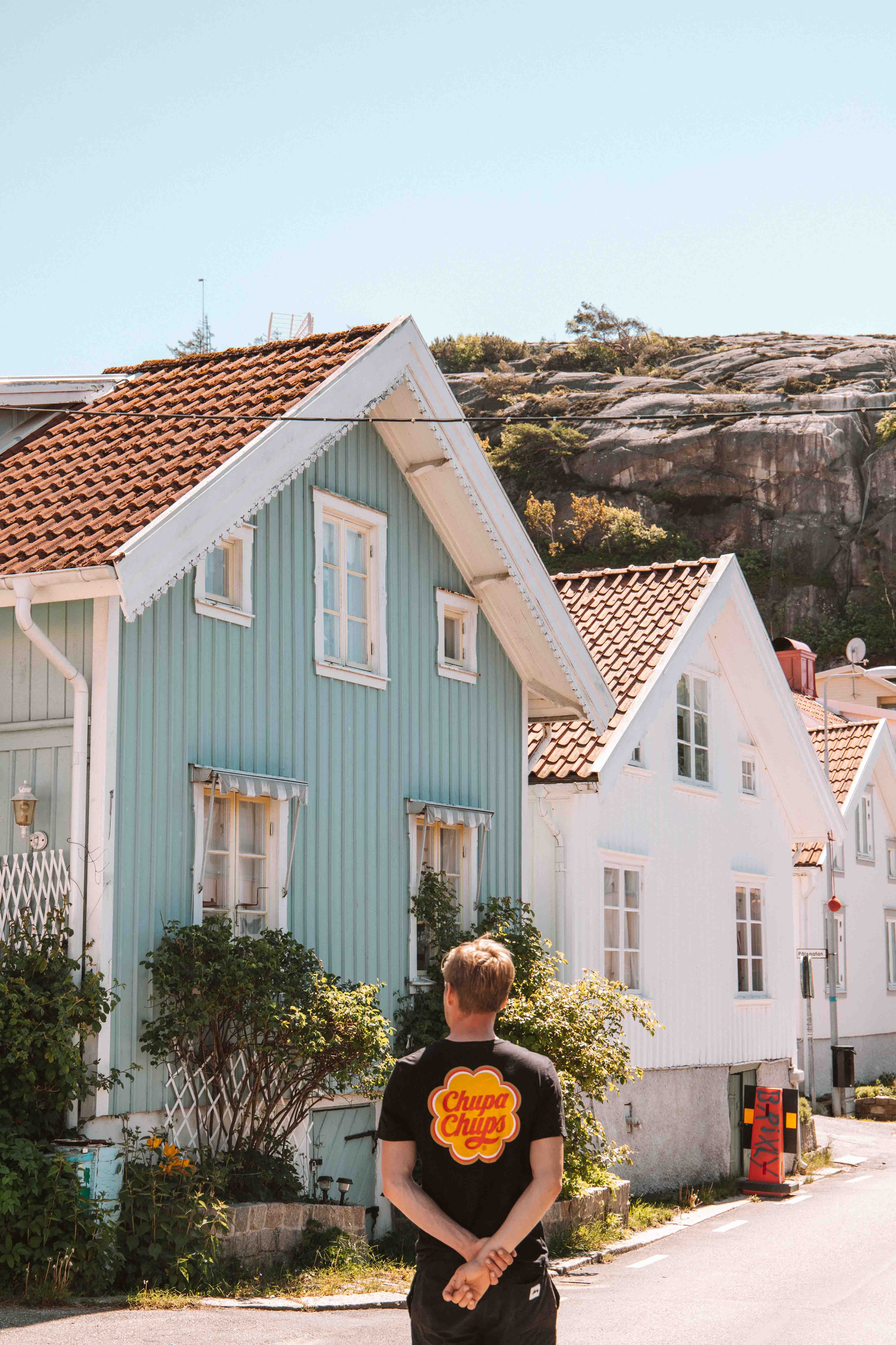boy walking among colourful wooden houses in fjällbacka