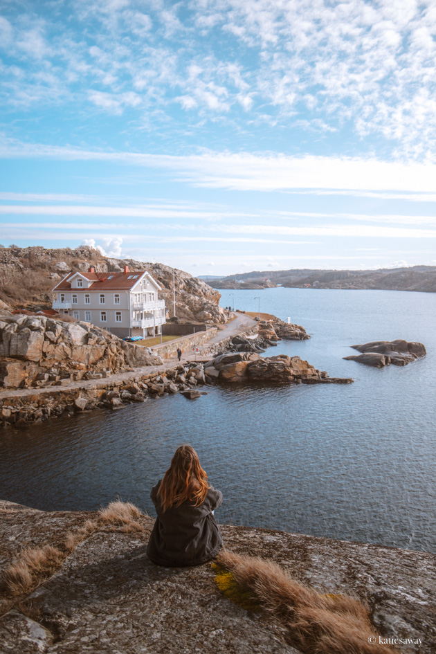 Girl sitting on a rock looking out into the sea on the west coast of marstrand island, sweden