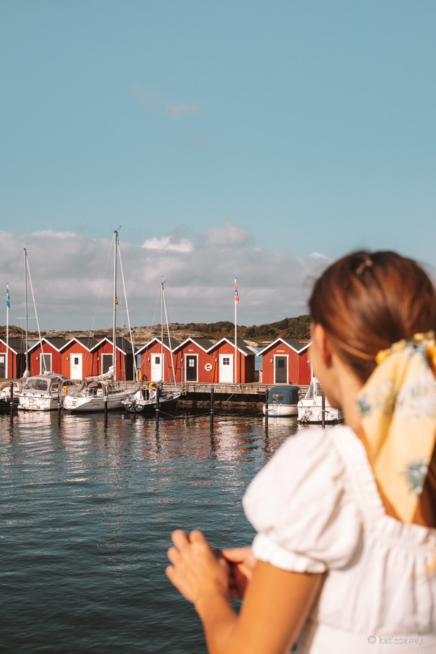 girl on a ferry looking out over red boat houses