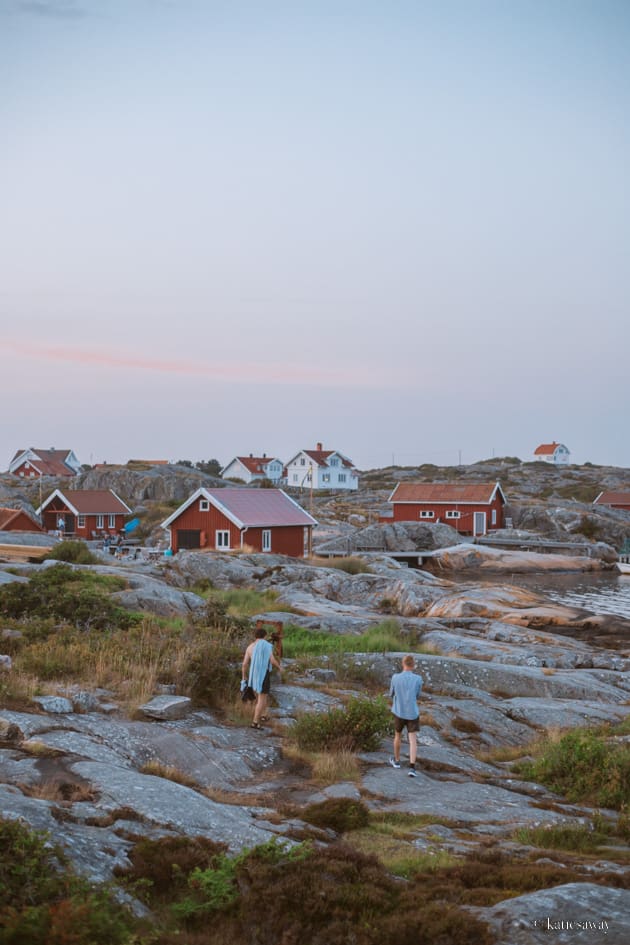 two people walking along the rocky cliffs of käringön, sweden