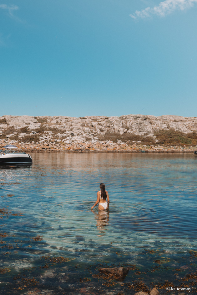 girl in a white bikini swimming in turquiose blue water near vinga island gothenburg