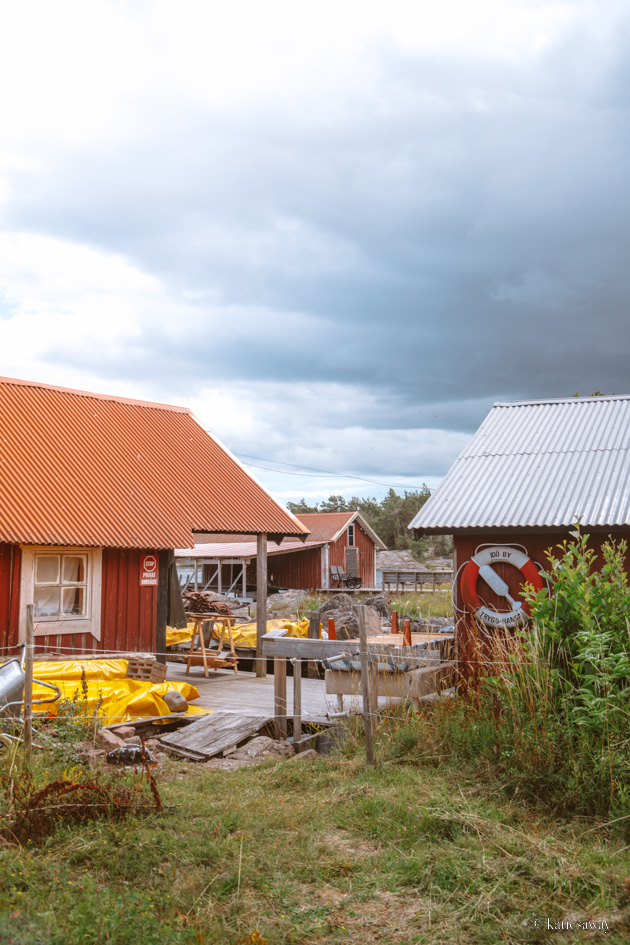 The small harbour in the village on idö with three red boat houses surrounding the water